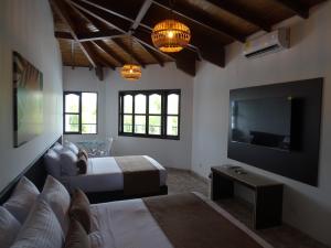 Playa VerdeHotel Palmas De Alcalá的一间卧室配有一张床和一台平面电视
