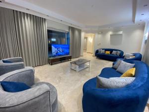 麦地那ملك فيلا的客厅配有2张蓝色沙发和电视