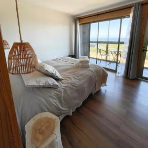 皮奇勒姆Refugio Lobos的一间卧室设有一张床,享有海景