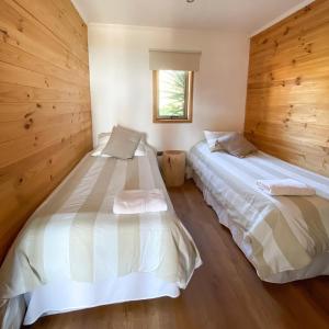 皮奇勒姆Refugio Lobos的木墙客房的两张床