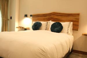 亚美尼亚UKO Urban Ekolodge的卧室配有白色床和2个绿色枕头