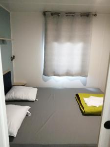 纳博讷普拉日Mobil-home (Clim)- Camping Narbonne-Plage 4* - 011的小房间设有窗帘窗户