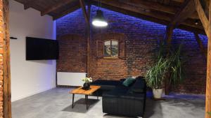 卡托维兹Parkcity Katowice Bogucice的带沙发和砖墙的客厅