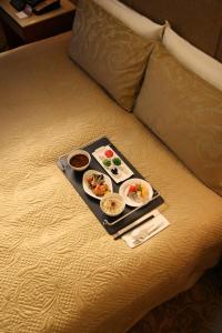 台北神旺商务酒店的床上装有两盘食物的托盘