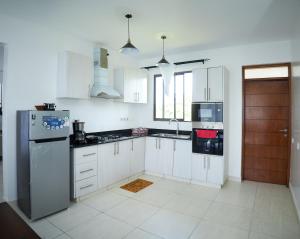 VipingoMonarch Villas - Kilifi的厨房配有白色橱柜和不锈钢冰箱