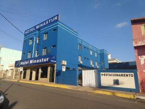 卡皮托利乌Hotel Minastur的街道边的蓝色建筑