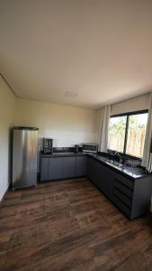 圣若热岛Vila Natur的带冰箱的空厨房,铺有木地板