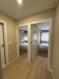波尔图Oporto Near Family Apartments的一间设有两张床的客房和一个带卧室的走廊