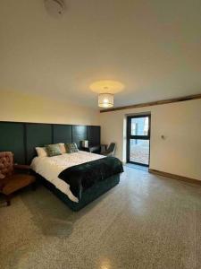 利默里克Moig Lodge - 7 Double Bedroom Barn Conversion的一间卧室配有一张大床和一把椅子