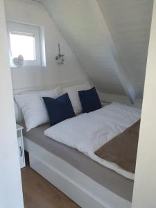 拉斯特Ein bisschen Luxusfeeling direkt am Neusiedler See的客房内的白色床和蓝色枕头
