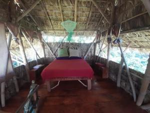 BalgueEl Bamboo Cabins的小屋里的一个床位