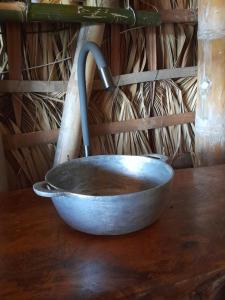 BalgueEl Bamboo Cabins的木桌顶上的金属碗
