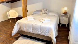 埃尔卡拉法特Alma Andina的一间卧室配有一张带白色床单和椅子的床