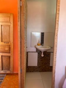 奥科苏尤Orlando´s House的一间带水槽、镜子和门的浴室