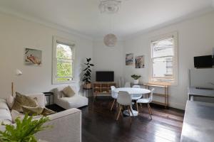 悉尼Surry Hills Chic right on Crown St的白色的客厅配有白色的桌子和椅子