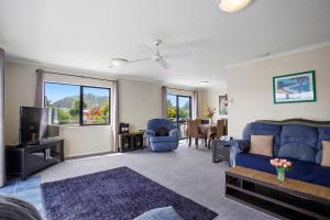 卡蒂卡蒂The Bowentown Bach - Waihi Beach Upstairs Unit的客厅配有蓝色的沙发和电视