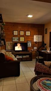 加罗帕巴Casa aconchegante térrea à 3min de carro do centro e praia central的客厅设有壁挂式平面电视。