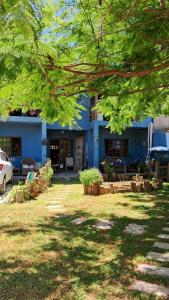 加罗帕巴Casa aconchegante térrea à 3min de carro do centro e praia central的前面有棵树的蓝色建筑