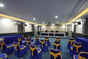 巴东Hotel Bhakti的一间设有蓝色和黄色椅子的房间和一个舞台