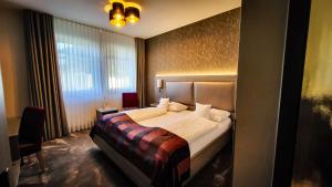 维林根维林最佳西方酒店的一间卧室设有一张床和一个大窗户