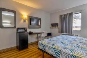 小石城Motel 6 Little Rock AR South的酒店客房设有一张床、一张书桌和一台电视机。