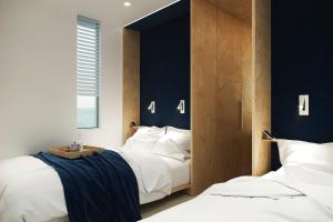 柏林Spreeapartment MARA的一间卧室设有两张床和蓝色的墙壁