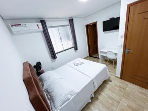 Lebrinhos hotel的客房设有床、窗户和书桌。