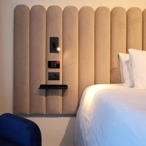 维佐拉提契诺TRIBE Milano Malpensa的酒店客房设有一张床和一面墙,