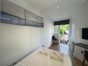 The HydeLovely one bedroom garden flat in Hendon的一间卧室配有一张床、一张书桌和一台电视