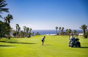 圣米格尔德阿沃纳Villa Saona Golf的一个人在高尔夫球场打高尔夫