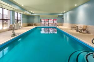 新奥尔巴尼Holiday Inn Express - New Albany的大楼内的一个蓝色海水游泳池