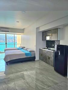 阿卡普尔科departamento con vista al mar的一间带大床的卧室和一间厨房