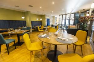 里瓦德奥HOTEL JAVIER MONTERO的用餐室配有桌子和黄色椅子