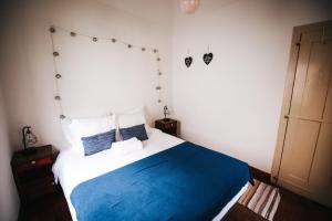 圣维森特Casa da Avo Rosa的一间卧室配有蓝色和白色床单