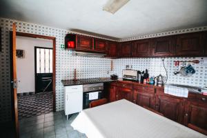 圣维森特Casa da Avo Rosa的厨房配有木制橱柜和白色炉灶烤箱。