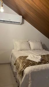 蒂安瓜Villa Suíça, Chalé Mezanino的卧室配有一张床铺,墙上配有电视