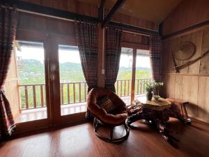 高平Trốn Homestay, Cao Bằng的客房设有椅子和带窗户的阳台