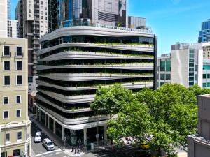 墨尔本Aspire Melbourne的一座有树木和汽车的城市的办公楼