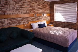 纳拉布赖纳拉布莱中城酒店的一间卧室配有一张床、一把椅子和一张沙发