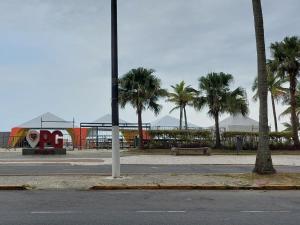 索莱马Cantinho de vó - Praia Grande - Aviação的一条拥有棕榈树公园和游乐场的街道