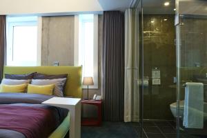 首尔Hotel Cocomo的一间卧室设有一张床和一个玻璃淋浴间