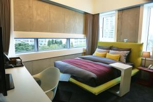 首尔Hotel Cocomo的卧室配有一张床、一张书桌和窗户。