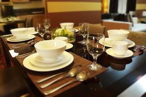 马尼拉BSA双子塔酒店的一张木桌,上面摆放着白色菜肴和酒杯