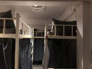 皮皮岛Phi Phi Green House & Sunsky Hostel的配有黑色枕头的客房内的两张双层床