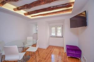 里斯本Oleiro 7的一间设有玻璃桌和紫色椅子的用餐室