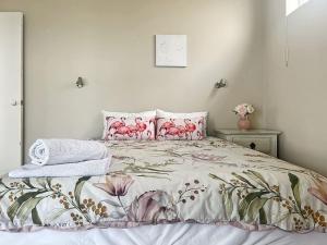 尼尔森湾Bayview Towers Unit 1 15 Victoria Parade的一间卧室,床上有粉红色的鲜花