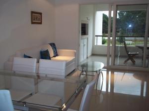 埃斯特角城Green Park Punta del Este的客厅配有白色沙发和玻璃桌