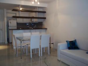 埃斯特角城Green Park Punta del Este的客厅配有桌椅和沙发