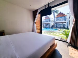 美奈Tuong Vy Boutique Hotel Mui Ne的一间卧室设有一张床和一个大窗户