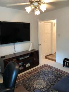 休斯顿2 room luxury suite near airport & The Woodlands的客厅配有平面电视和椅子。